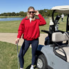 Woman in a red CourtLife Happiest on the Course Quarter Zip Golf Sweatshirt standing by a golf cart on the course